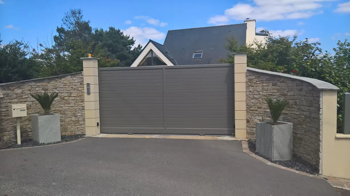 Portail coulissant aluminium et mur en pierre à l'entrée d'une propriété, Terracity