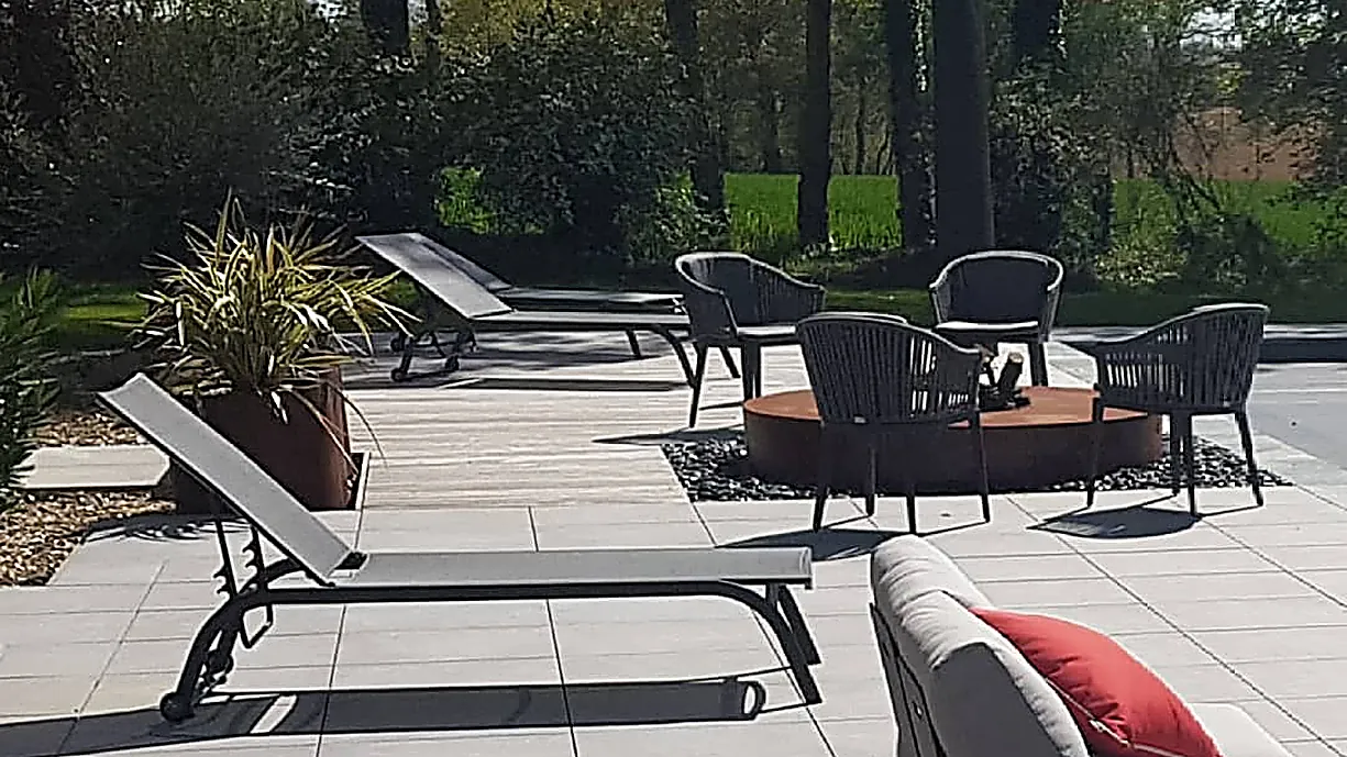 Terrasse dallée avec transats et salon de jardin autour d'un brasero, Terracity
